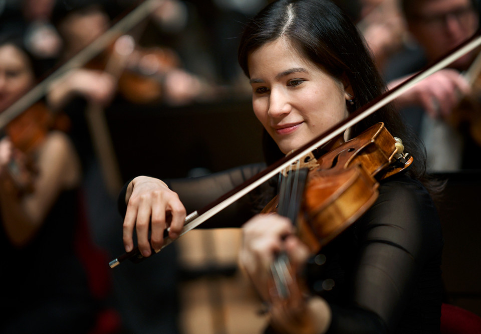 Kvinna som spelar violin. Fotografi.