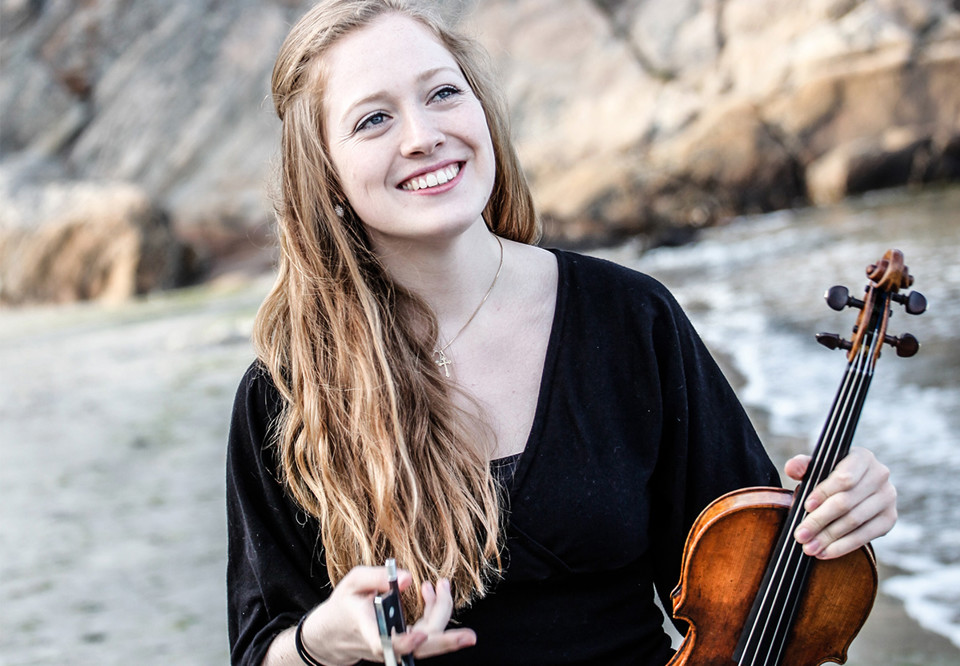 Kvinna som håller i en violin. Fotografi.